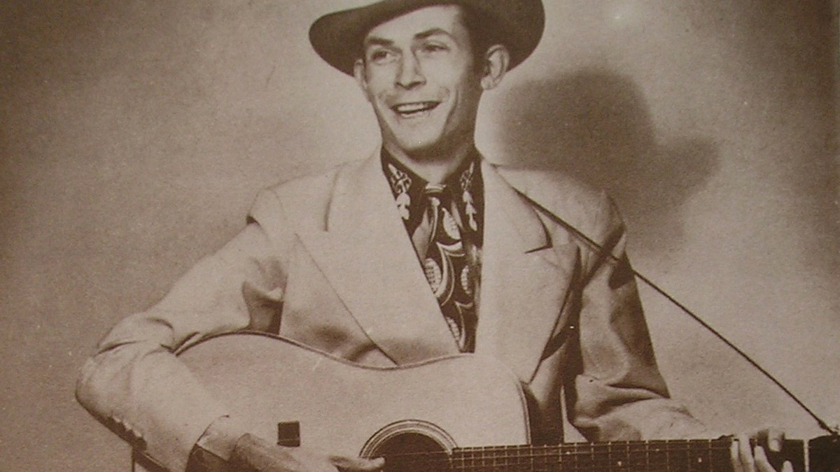 Hank Williams tocando la guitarra en una imagen promocional de MGM Records